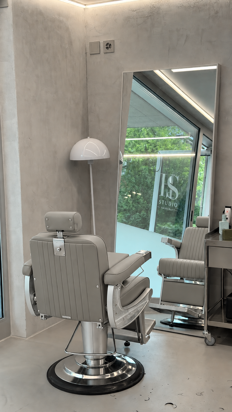 HS-Studio — ljusgrå barberarstol framför spegeln